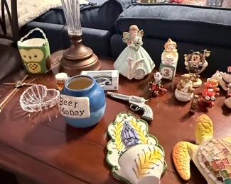 Crystal-style table lamp, Disney collectibles, angel figurines, decorative crosses, trinket dishes, ceramic turtle, novelty "Beer Money" jar, toy cap gun, and assorted tabletop décor. Items sold individually unless noted.