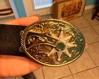 **Western Belt Buckle** – Large oval Western-style belt buckle featuring an engraved scroll design and a six-point sheriff's star at the center with rope-edge detailing. A great accessory for Western wear or belt buckle collectors. Sold as found.
