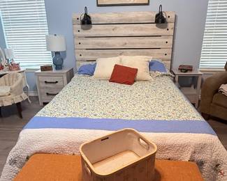 Queen-size bed featuring a rustic wood plank headboard, upholstered bench, vanity with mirror and matching stool, nightstand, table lamp, and decorative accessories. A well-coordinated collection for furnishing a bedroom.