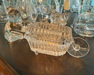 Princess House Crystal Wheelbarrow – Princess House crystal wheelbarrow planter featuring ribbed crystal sides, rolling wheel detail, and decorative handles. A charming display piece for flowers, candy, or seasonal décor, and a wonderful addition to a Princess House collection. Sold as found.