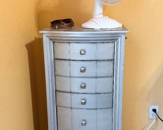 Jewelry Armoire – Tall jewelry armoire featuring six drawers and a hinged side compartment design for organizing jewelry and accessories. Finished in a distressed gray wood tone with decorative hardware. A stylish and functional storage piece for a bedroom or dressing area. Sold as found.