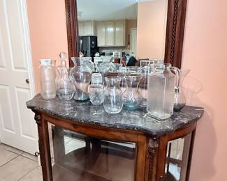 Vintage Curio Cabinet – Curved front curio cabinet featuring a decorative wood frame, marble-look top, mirrored back, and glass display shelves. Displayed with an assortment of glassware, including several Princess House pieces. A beautiful cabinet for showcasing crystal, collectibles, or decorative accents.