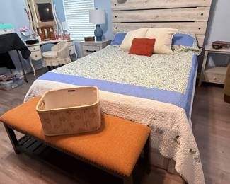 Queen-size bed featuring a rustic wood plank headboard, upholstered bench, vanity with mirror and matching stool, nightstand, table lamp, and decorative accessories. A well-coordinated collection for furnishing a bedroom.