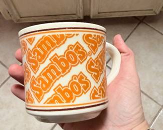 **Vintage Sambo's Coffee Mug** – Vintage ceramic Sambo's restaurant coffee mug featuring the iconic orange logo pattern. A nostalgic piece of restaurant memorabilia for collectors of vintage advertising and diner collectibles. Sold as found.