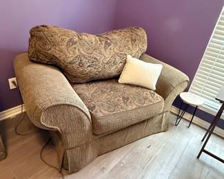 Oversized Upholstered Chair – Oversized upholstered chair featuring rolled arms, a paisley back cushion, and textured coordinating fabric. A comfortable seating option for a living room, bedroom, or reading nook. Sold as found.