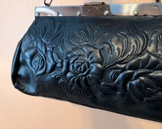 Vintage Embossed Leather Handbag – Black leather handbag featuring an embossed floral design, silver-tone frame, and chain strap. A classic vintage accessory suitable for everyday use or special occasions. Sold as found.