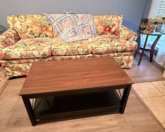 loral upholstered three-cushion sofa with rolled arms and loose seat cushions. Also pictured are a wood coffee table with lower shelf and a side accent table. Items sold individually unless noted.