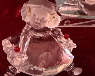 #167 - $70 - Swarovski Santa in a sleigh and a sitting little girl