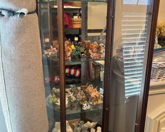One of two matching curio cabinets with collectibles 