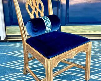 $2,400 - Set of 8 Chippendale chairs featuring a gold gilt hand-painted finish and covered in blue velvet upholstery. Comes with 8 velvet custom bolster pillows - side chair 22x19x38, arm chair 23x19x38