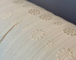 Upclose image of the soft buttercream color patterned fabric on the chaise lounge chair