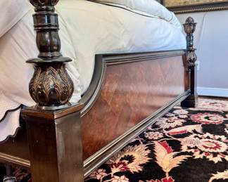 Close up of the intricate details on the dark wood bed post featuring carved acanthus leaf motif and rounded final top.