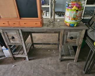 Rustic farmhouse style writing desk or console table with weathered wood finish, two drawers, and open lower shelving.