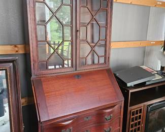 Beautiful antique two piece secretary desk with removable glass display cabinet top, drop front writing surface, serpentine drawers, decorative hardware, and key included.