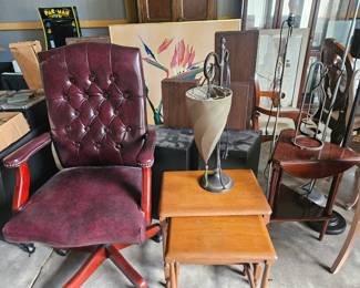 Burgundy tufted office chair with nailhead trim, vintage nesting tables, and some lamps.