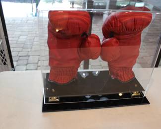 PAIR OF BOXING GLOVES SIGNED BY EVANDER HOLYFIELD. WERE OBTAINED IN 1992 AT AN AUCTION BY MEMBERS OF THE SECRET SERVICE TO RAISE FUNDS FOR VICTIMS OF HURRICANE ANDREW IT WAS HELD AT JACKSONVILLE GOLF AND COUNTRY CLUB