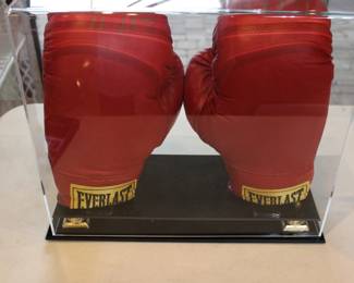 PAIR OF BOXING GLOVES SIGNED BY EVANDER HOLYFIELD. WERE OBTAINED IN 1992 AT AN AUCTION BY MEMBERS OF THE SECRET SERVICE TO RAISE FUNDS FOR VICTIMS OF HURRICANE ANDREW IT WAS HELD AT JACKSONVILLE GOLF AND COUNTRY CLUB