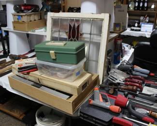 STAIN GLASS WINDOW, ALL THE ITEMS IN FRONT OF THE WINDOW IS EVERYTHING YOU NEED TO MAKE STAIN GLASS WINDOWS. THE BUCKET UNDER THE TABLE HAS AN ASSORTMENT OF BROKEN COLORED GLASS
