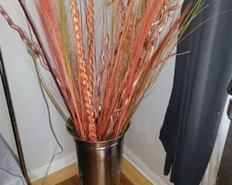 Oversized polished chrome floor cylinder vase with tall decorative terracotta autumn reeds.