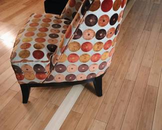 Side angle view of modern curved barrel-back accent armchair with heavy hardwood frame.