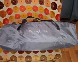 Dream On Me Nest portable travel playpen neatly folded inside original canvas shoulder bag.