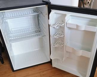 Interior view of clean Danby mini-fridge showing built-in door beverage can holders.