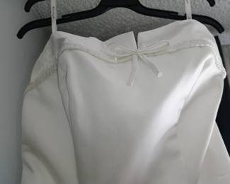 Close-up view of pristine beaded neckline trim on brand new David's Bridal wedding gown.