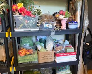 Black metal 4-tier storage shelving rack
Condition: Good
Black metal 4-tier open shelving/utility rack with straight rectangular frame and broad shelves. Appears to be a freestanding storage unit rather than a branded cart. Shelves are loaded with mixed artificial flowers, baskets, boxes, and decor supplies; those contents are secondary and not included in valuation except as a reminder that the unit is being used for storage.