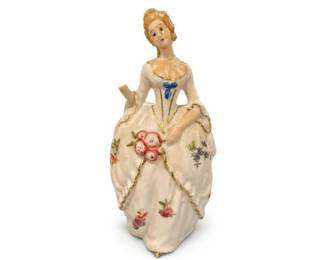 Porcelain Lady Figurine with Floral Dress Decoration
Condition: Good
Cream/white porcelain lady figurine wearing a low-neck, full-skirted dress with painted floral sprays, gold trim, and a blue bow at the bodice. The figure appears hand-painted and decorative, with a small but elegant 20th-century display-figurine style. No base mark is visible in the provided image.