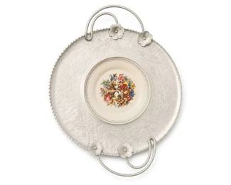 Silverplate round handled serving tray with porcelain floral center insert
Condition: Good
Round silverplate serving tray/platter with two loop handles, flower-shaped handle mounts, embossed floral/scroll decoration, beaded rim, and a centered porcelain-looking floral medallion or insert. Surface shows light age-appropriate tarnish; no obvious major damage is visible from the photo. Comparable sold eBay listings show similar generic ornate silverplate trays and handled platters. ([ebay.com](https://www.ebay.com/itm/127824326549?utm_source=openai))