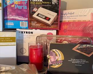 Xyron 510 Creative Station 5" craft laminator/sticker maker
Condition: Good
Boxed Xyron 5-inch Creative Station craft machine shown in front-center of the image. Surrounding items include other craft/office goods, such as a Pulsonic blood pressure monitor box, a candle, and miscellaneous packaging, but those are secondary and not treated as separate salable objects here.