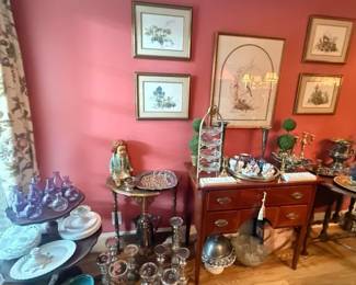 Amethyst Purple Art Glass Perfume Bottle
Condition: Good
Small amethyst-purple blown glass bottle with stopper-like top/closure visible in a mixed estate-sale display. Visible evidence supports a decorative perfume/bottle/decanter type, but not a specific maker or model.