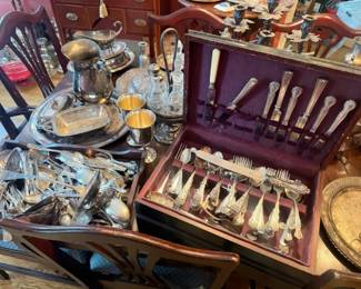 Reed & Barton Francis I–style silver flatware and serving-piece collection in fitted case
Condition: Good
Vintage ornate silver-colored flatware and serving pieces in a fitted presentation case, with multiple teaspoons/forks/spoons, serving implements, trays, and additional loose pieces visible on the table. Ornate floral and scroll decoration is consistent across many handles.