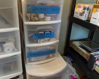 Clear Plastic 5-Drawer Storage Tower Organizer
Condition: Good
Clear plastic vertical storage tower with five pull-out drawers. The visible handwritten labels suggest it is being used for children's supplies, photos/paper, and stationery/crafts. Condition appears used but serviceable; the drawer fronts and frame show normal wear from household use.