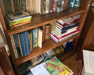 Dark brown wood veneer 3-shelf bookcase
Condition: Fair
Freestanding rectangular bookcase in dark brown stained wood/veneer with three visible shelf levels and mixed paperback/hardcover books inside. Visible wear and scuffing on shelf edges and finish. No doors, glass, or special hardware visible.
