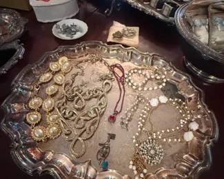 Mixed Vintage Costume Jewelry Estate Lot with Rhinestone Necklaces, Bracelets, Brooches, and Earrings
Condition: Good
Assorted estate-style costume jewelry lot on a silver-plated or silver-tone tray, including rhinestone and faux-pearl pieces, chain necklaces, bracelet(s), brooch/pin items, and a few smaller accessories. Condition appears mixed but generally wearable/displayable from the photo; exact completeness and authenticity of individual pieces are unverified.