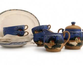 Unmarked hand-painted blue scenic pottery tea set
Condition: Good
Blue-glazed hand-painted scenic tea ware showing a rural house/tree landscape, with tan/brown rims and handles. Visible pieces appear to include a large plate or platter, multiple cups/saucers, a creamer, and a lidded pot or sugar bowl. Likely sold as a decorative tea set or child-sized tea service.