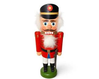 Wooden Nutcracker Soldier Christmas Figurine with Black Hat and Green Base
Condition: Good
Painted wooden nutcracker-style soldier with black cap, red coat, white beard/hair, white pants, black boots, green circular base, and a dark staff or sword held at the side. Overall looks like a decorative Christmas collectible rather than a functional toy.