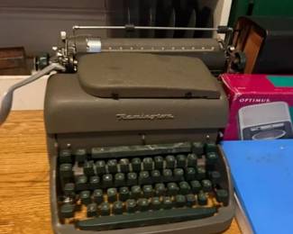 Remington portable manual typewriter
Condition: Fair
Single Remington portable manual typewriter with olive-gray body and dark green keys. Visible cosmetic wear consistent with age/use. Exact model and working status are not confirmed from the photo.