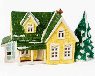 Ceramic lighted Christmas village house with evergreen tree
Condition: Good
Small decorative ceramic holiday house in yellow and green with white snowy accents, multi-window facade, porch, and a separate evergreen tree beside it. Likely intended as seasonal tabletop village decor; lighting function is unconfirmed from the image.