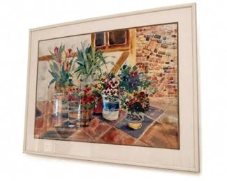 Framed watercolor floral still life wall art
Condition: Good
Framed floral still-life watercolor-style artwork under glass with a wide light mat and pale frame. The visible composition shows multiple potted flowers against an interior/patio-like background. The glass reflection makes it difficult to determine whether this is an original watercolor, a print, or a reproduction.