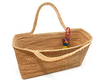 Woven natural fiber market basket with handle
Condition: Good
Rectangular handwoven basket in natural fiber with a tall loop handle and open top. Appears to be a general-purpose market/picnic/storage basket. Visible condition looks good from the provided image, with normal surface variation expected for woven material. A small decorative dangling charm is present but does not appear original to the basket.