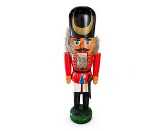 Wooden Nutcracker Soldier Christmas Figurine
Condition: Good
Hand-painted wooden nutcracker soldier with black shako-style hat, red jacket, white trousers, black boots, mustache, fur side hair, and faux beard. Likely decorative Christmas/holiday display piece. Condition appears generally good from the front, with normal display wear possible; underside and rear not visible.