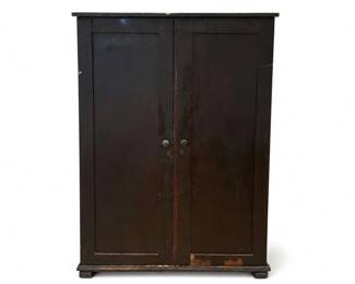 Dark Wood Two-Door Armoire / Storage Cabinet
Condition: Fair
Tall dark wood cabinet with two full-height paneled doors, simple molded top and base, small round knobs, and noticeable wear/chipping along the lower front edge. Likely an armoire, wardrobe, or general storage cabinet; interior and back are not shown, so shelf configuration and original use remain unverified.