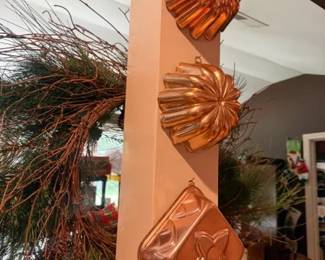 Copper Wall-Hanging Gelatin Molds, 3-Piece Set
Condition: Good
Three copper-colored wall décor molds hanging vertically on a post: two shell/fluted forms and one diamond-shaped molded form with a floral motif. The pieces appear decorative rather than for active kitchen use, with visible hanging loops/hooks.