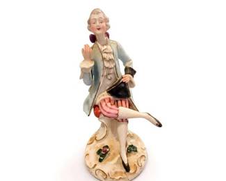 Art Deco porcelain dancing lady figurine
Condition: Good
Hand-painted porcelain figurine of a posed female dancer/lady in a blue coat, ruffled blouse, pink striped skirt, and black accessory/purse. White molded base with gilt scrolls and small floral accents. Surface appears intact from the front view; underside and back are not visible.