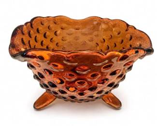 Fenton-style amber hobnail pedestal compote bowl
Condition: Good
Amber/orange pressed glass hobnail compote or candy dish with ruffled rim and three-foot pedestal base. Decorative vintage glass serving piece; likely used for candy, nuts, or display. Comparable search results show similar amber hobnail pedestal compotes and Fenton-style pieces, supporting the object type but not a definitive maker ID. ([ebay.com](https://www.ebay.com/itm/366388932302?utm_source=openai))
