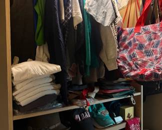 Mixed men's clothing and accessories closet lot
Condition: Good
Assorted used clothing lot from a closet, including hanging shirts/sweaters, folded tops, hats, a plaid scarf or blanket, and tote bags. The lot appears mixed by style and size, with no obvious high-end designer pieces visible.