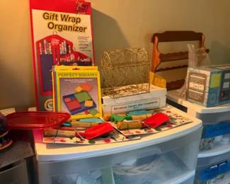 Red Gift Wrap Organizer Storage Bag/Boxed Organizer
Condition: Good
Primary item appears to be a boxed gift wrap organizer in red packaging. Other storage baskets and small organizers are visible in the scene, but they are secondary and not treated as separate identified items.