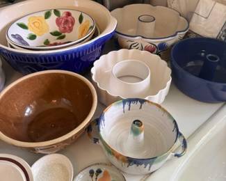 Stoneware mixing bowl assortment with handled batter bowl and drip-glaze ceramics
Condition: Good
Mixed lot of ceramic/stoneware kitchen vessels: at least one large blue-and-white nesting/mixing bowl, a scalloped cream bowl, a brown glazed bowl, a handled drip-glaze batter bowl, and smaller assorted bowls/dishes. Condition appears used but generally intact from the visible side; no obvious large cracks are visible in the photo. There may be additional matching or unrelated pieces outside the frame.